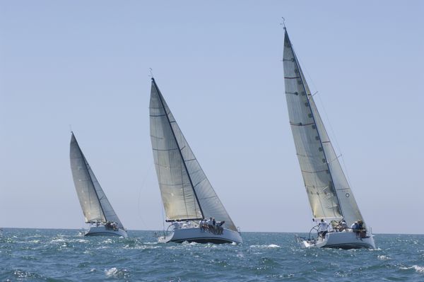 نمایی از سه قایق بادبانی که در رویداد قایقرانی تیمی به رقابت می پردازند
