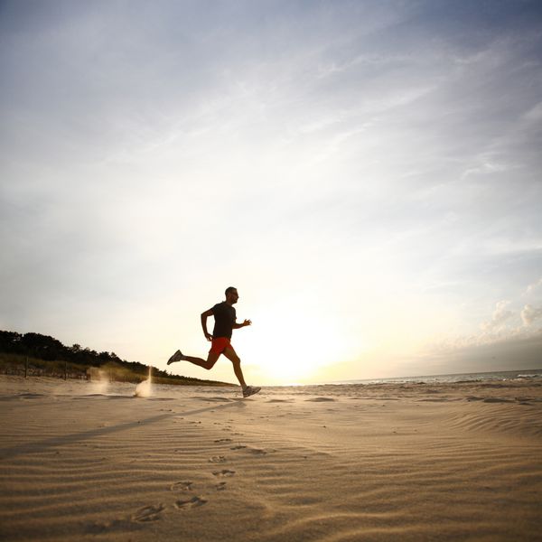 مردی که در غروب آفتاب در ساحل می دود