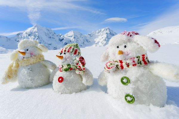 زمستان برف خورشید و سرگرمی کریسمس - دوستان آدم برفی شاد و کوه های برفی در پس زمینه