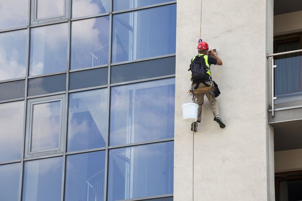 تعمیر و نگهداری ساختمان مردی که در ارتفاع کار می کند