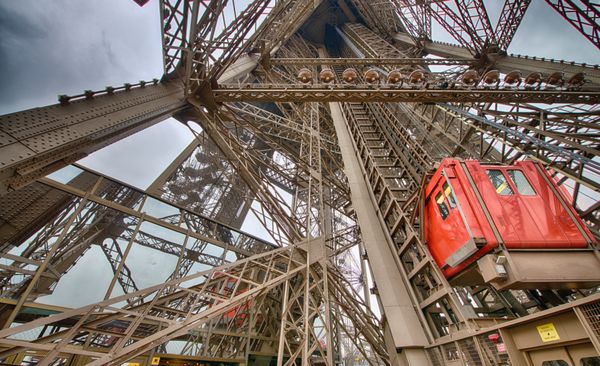 پاریس آسانسورهای برج ایفل unus که مسافران را به سکوهای تماشا می برد آنها بر روی پایه های برج قرار دارند و انحنای سازه را دنبال می کنند