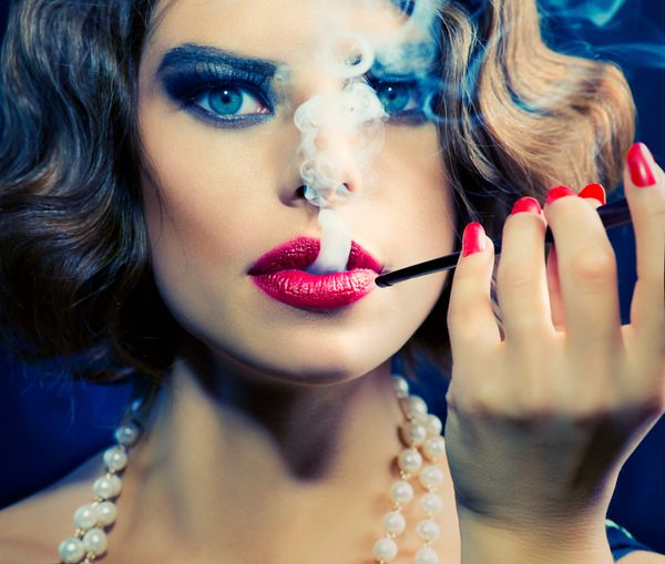 پرتره زن رترو سیگاری دختر زیبایی با دهانی بانوی زیبا با سیگار مدل قدیمی مدل مو و آرایش