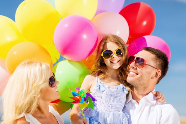 تعطیلات تابستانی جشن مفهوم کودکان و مردم - خانواده با بادکنک های رنگارنگ