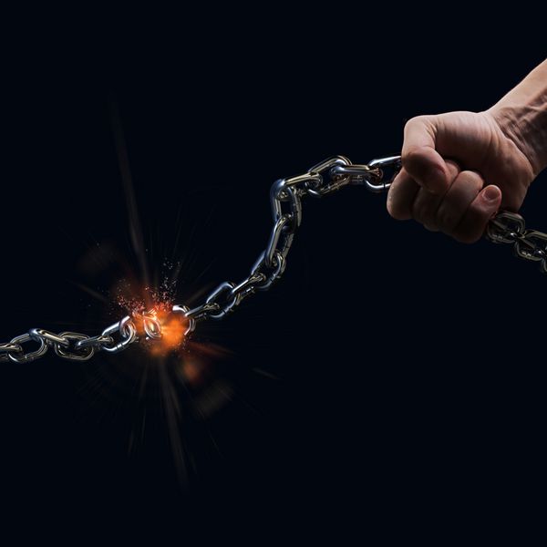 مردی که با دست یک زنجیر فولادی سنگین را به عنوان نماد مفهومی آزادی پاره می کند