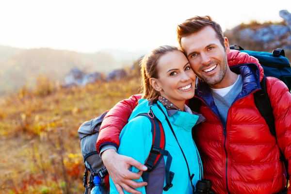 زن و شوهر جوان در کوه در حال لبخند زدن