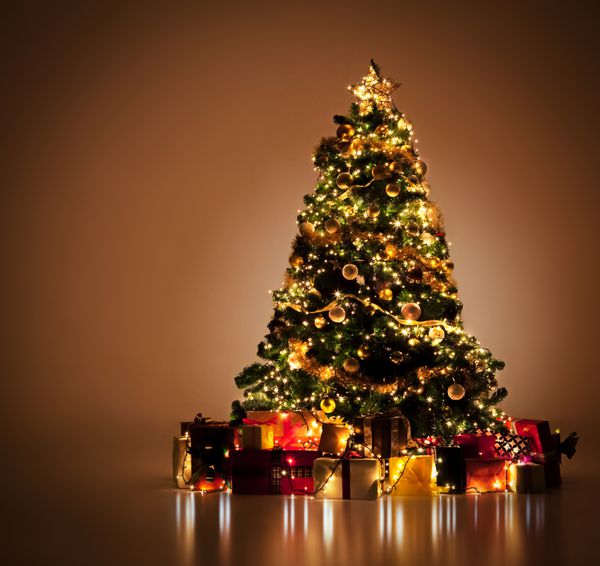 درخت کریسمس به زیبایی تزئین شده با هدایای زیادی در زیر آن