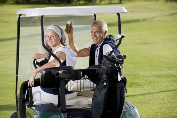 زوج شاد سالخورده روی چرخ دستی گلف