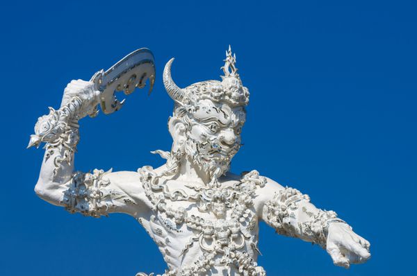 چیانگ رای - 11 ژانویه غول سفید با مجسمه شمشیر در آسمان آبی وات رونگ خون فرهنگ معابد هنری تایلندی در استان چیانگ رای تایلند در 11 ژانویه 2014 است