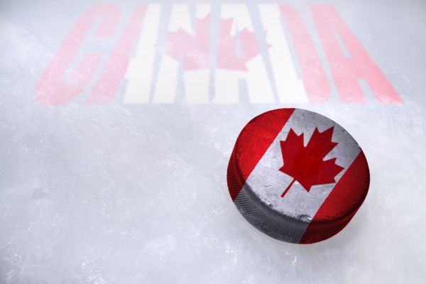 توپ قدیمی هاکی قدیمی با پرچم کانادا روی یخ است