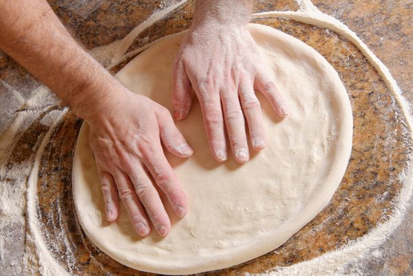 آشپز در حال تهیه خمیر پیتزا