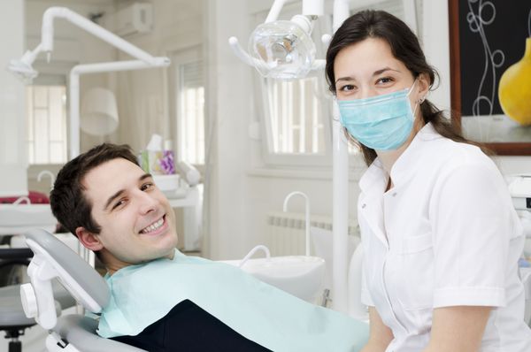 مرد جوان با دهان باز هنگام معاینه دهان در دندانپزشک