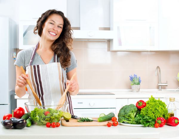 زن جوان در حال آشپزی در آشپزخانه غذای سالم - سالاد سبزیجات رژیم غذایی مفهوم رژیم غذایی سبک زندگی سالم آشپزی در خانه غذا آماده کن
