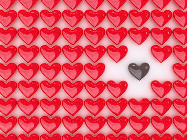 قلب شکلاتی بین انبوهی از قلب های قرمز - مفهوم نژادپرستی