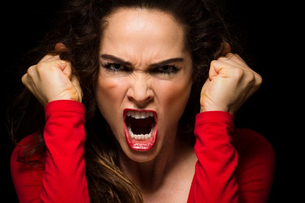 یک زن پرخاشگر بسیار عصبانی مشت هایش را از عصبانیت گره می کند
