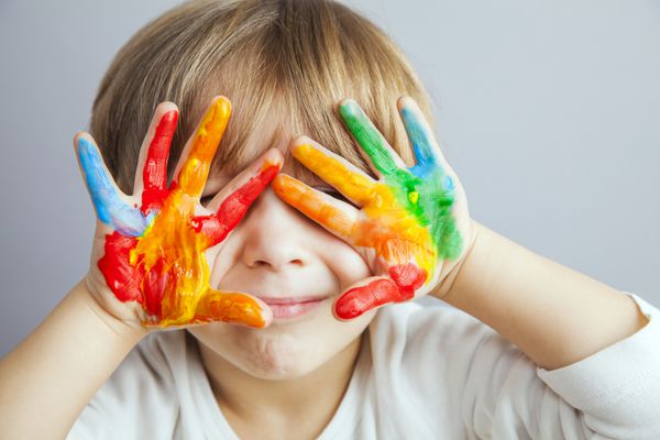 دست های دختر و پسر کوچک که با رنگ های رنگارنگ نقاشی شده اند