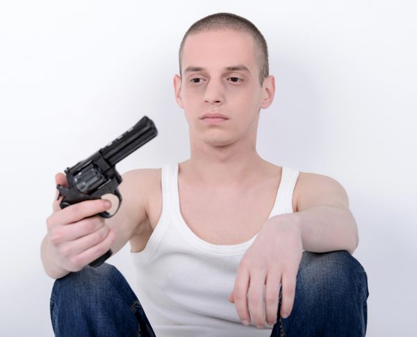 خودکشی کردن مرد جوان افسرده که اسلحه را نزدیک سرش گرفته است