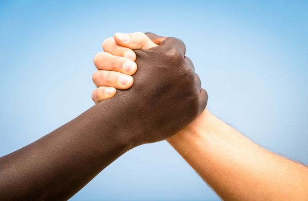 دستان سیاه و سفید انسان در یک دست دادن مدرن برای نشان دادن دوستی و احترام به یکدیگر - کشتی بازو علیه نژادپرستی