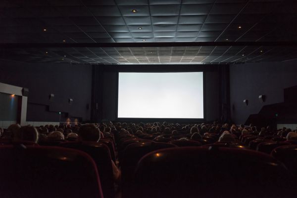 پرده خالی سینما با تماشاگر آماده برای اضافه کردن تصویر شما