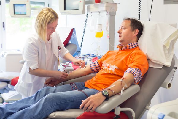 اهداکننده خون در هنگام اهدا با یک توپ فنری در دست