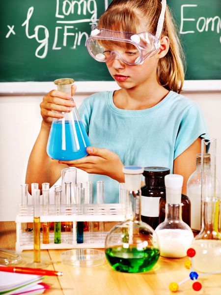 بچه در دست گرفتن فلاسک در کلاس شیمی