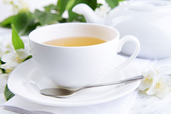 فنجان چای با یاس روی میز از نمای نزدیک
