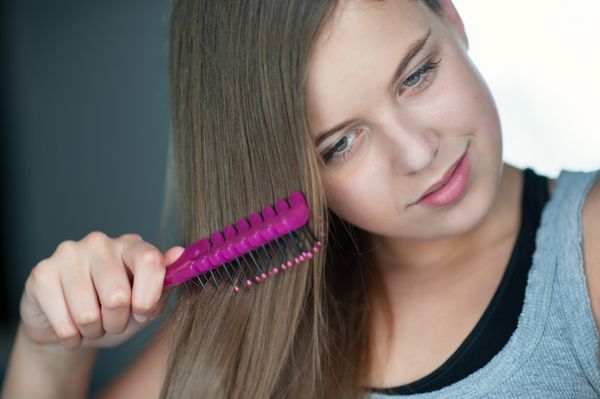 دختری که موهایش را شانه می کند