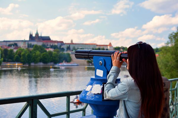 دختر از طریق تلسکوپ در پراگ نگاه می کند