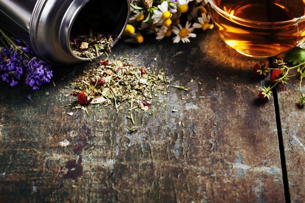 چای گیاهی و گل های ارگانیک وحشی در زمینه چوبی