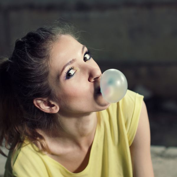 دختر زیبا در حال باد کردن حباب آدامس دختر هیپستر مدرن در فضای باز سبک زندگی