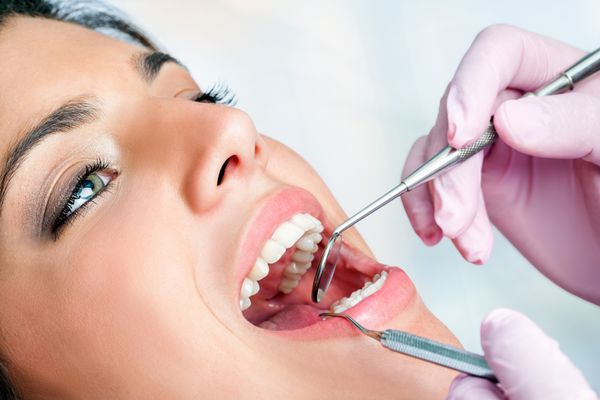 ماکرو نزدیک از زن در حال معاینه دندان در کلینیک