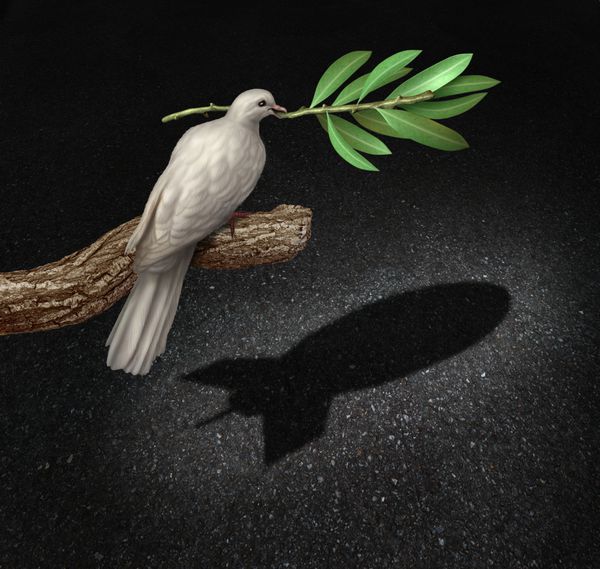 مفهوم خطر جنگ به مثابه آزادی کبوتر شارلاتان که شاخه زیتون را در دست گرفته و با تظاهر به شرم آور بودن سایه ای را که به شکل بمب به عنوان نمادی از خطر جنگ در می آید
