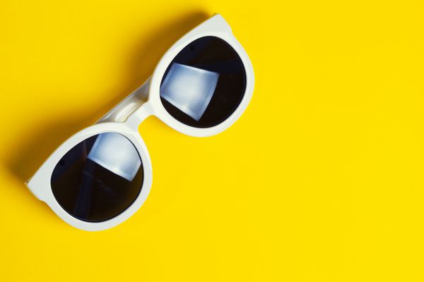 عینک آفتابی سفید شیک در زمینه زرد