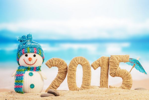 علامت سال نو 2015 با آدم برفی در پس زمینه ساحل