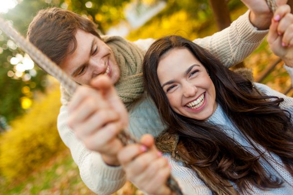 مفهوم عشق رابطه خانواده و مردم - زوج خندان در پارک پاییز در آغوش گرفته اند