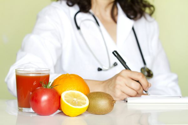 دکتر متخصص تغذیه در مطب با مفهوم رژیم غذایی میوه های سالم