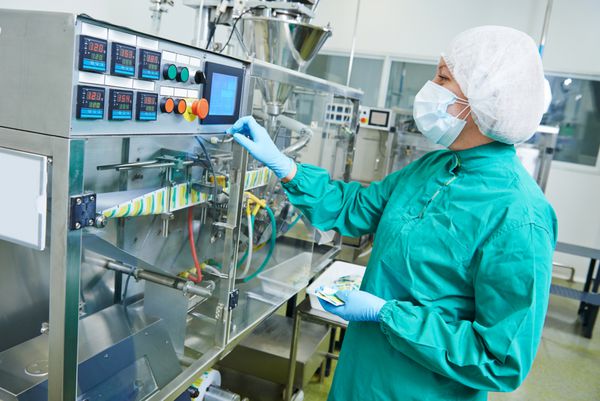 کارگر زن کارخانه داروسازی که خط تولید را در کارخانه تولیدی صنعت داروسازی راه اندازی می کند