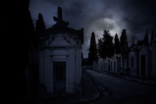 گورستان قدیمی اروپایی در یک شب ماه کامل ابری