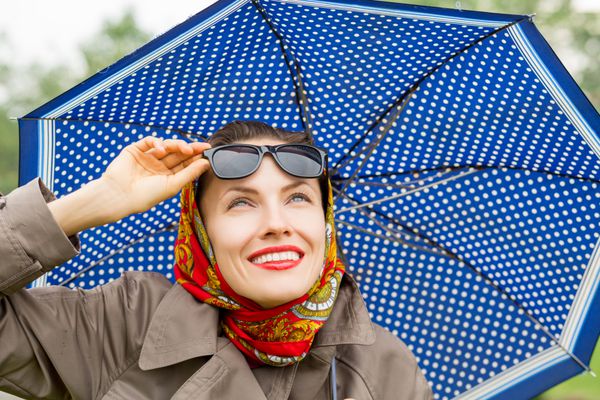زن شاد پاییزی با چتر به بالا نگاه می کند از روز جدید لذت ببرید