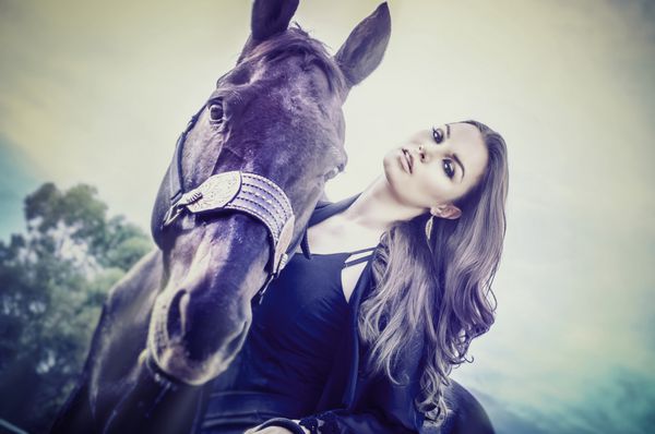 زن جوان زیبا و زیبا و اسب تراشیده
