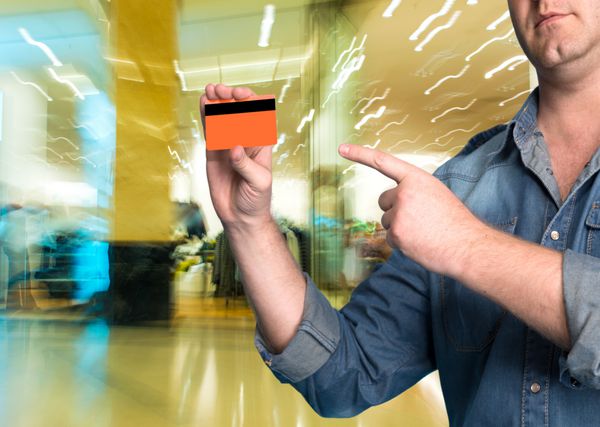 مردی که در مرکز خرید کارت اعتباری در دست دارد