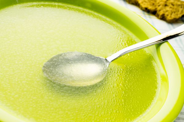 سوپ شفاف آبگوشت آبگوشت در بشقاب سبز