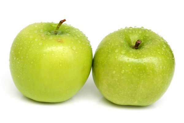 سیب سبز جدا شده در پس زمینه سفید