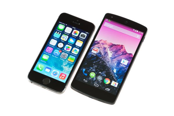 کی‌یف اوکراین - 29 سپتامبر 2014 نمای نزدیک از گوشی‌های هوشمند اپل iPhone 5s و Google Nexus 5 که روی پس‌زمینه سفید جدا شده‌اند