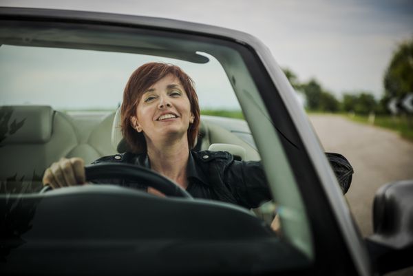 زنی که از رانندگی با ماشین کانورتیبل خود لذت می برد