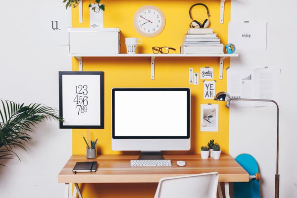 دفتر کار با کامپیوتر کار خلاقانه مدرن روی دیوار زرد