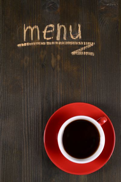 منوی نوشته روی تخته چوبی با نمای نزدیک فنجان چای