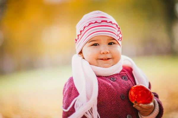 دختر بچه در حال خوردن سیب در پاییز
