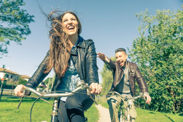زوج در حال دوچرخه سواری و تفریح - گردشگران در حال رانندگی در شهر - دو دوست در حال دوچرخه سواری در حومه شهر