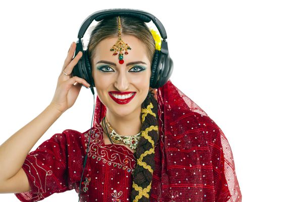 زن جوان هندی زیبا در حال گوش دادن به موسیقی با هدفون