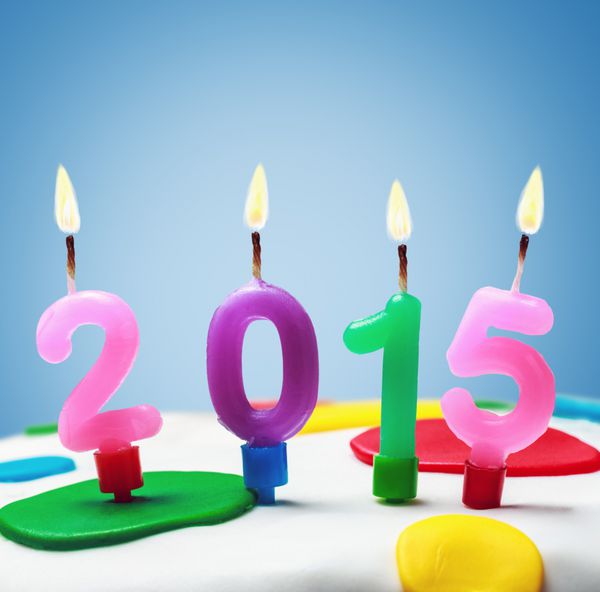 شمع های سوزان با نماد سال جدید 2015 روی کیک